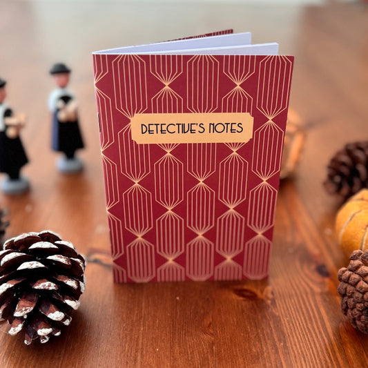 Notebook titled 'Detective's Notes' on a wooden surface with decorative elements.