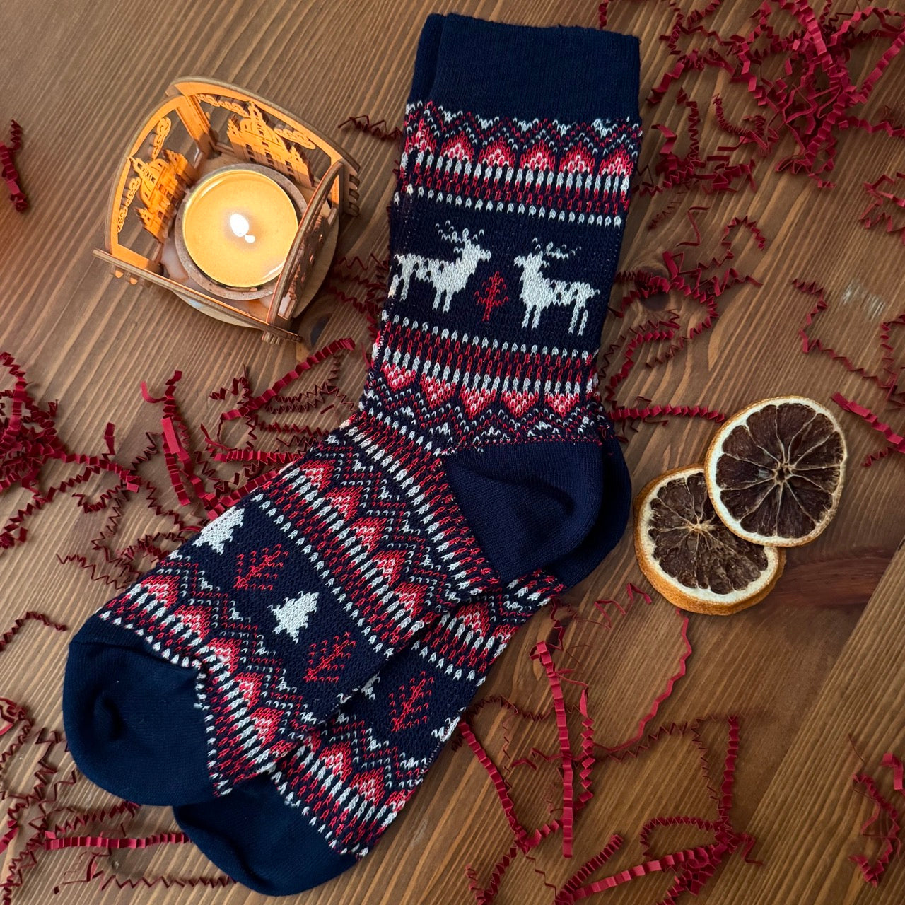 Socks in Nordic design, part of the cozy murder mystery gift box. Shown among decorative items.