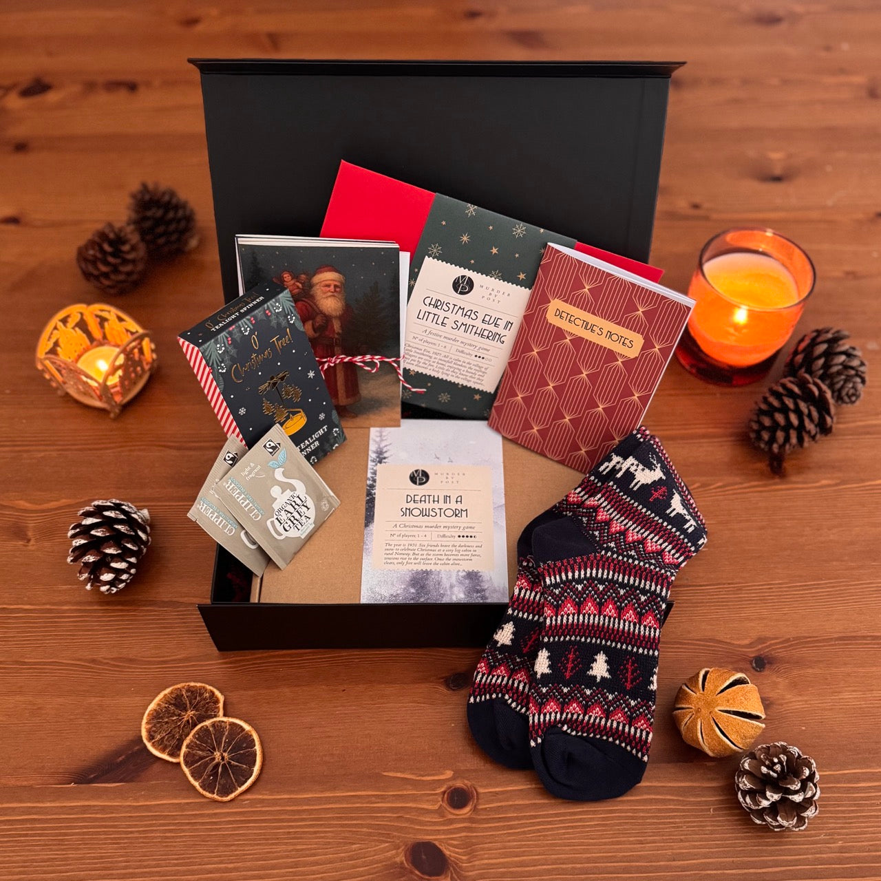 Picture of opened cozy murder mystery gift box, showing various items included in the box.