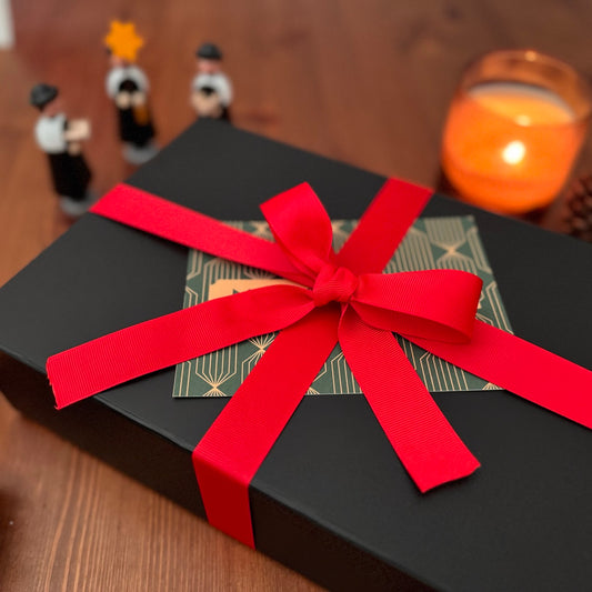 Close up of cozy murder mystery gift box. Shown among decorative items.