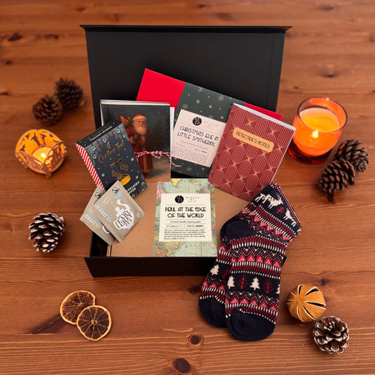 Picture of opened cozy murder mystery gift box, showing various items included in the box.