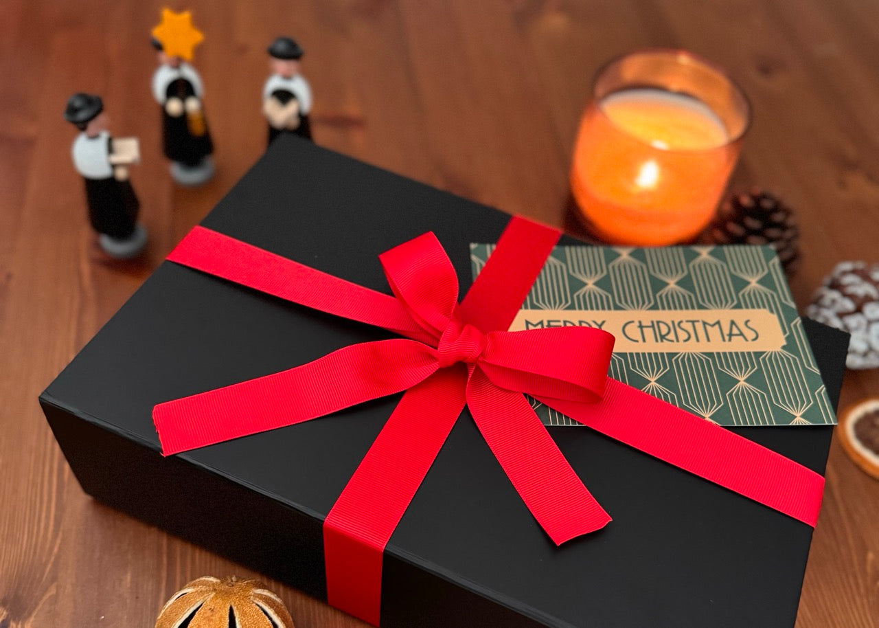 Cozy murder mystery gift box. Shown among decorative items.